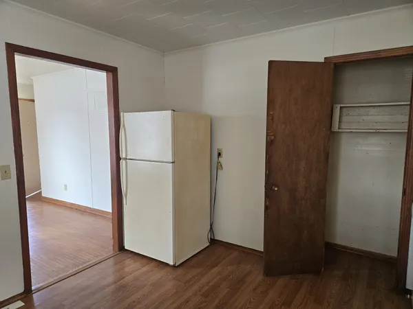 a view of a refrigerator in kitchen and wooden floor