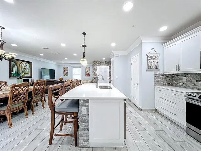 a kitchen with a table chairs sink and cabinets