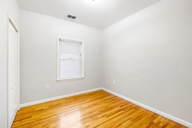 a view of a room with wooden floor and a bathroom