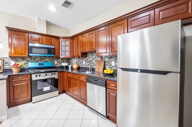 a kitchen with stainless steel appliances a refrigerator sink and cabinets