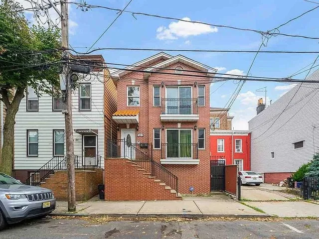 a front view of a building with a cars parked