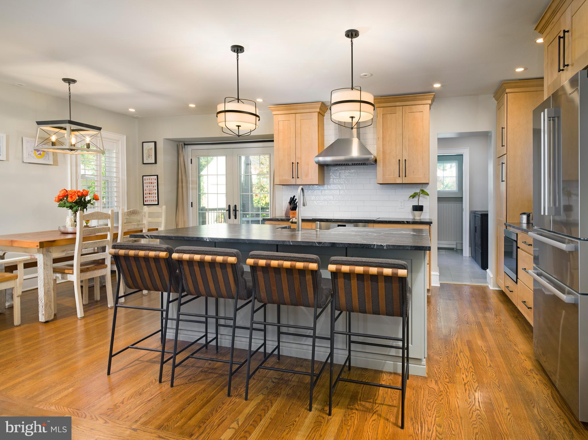 11 Shirley Road Narberth, PA 19072 - Photo 15 of 44 a kitchen with stainless steel appliances granite countertop a stove top oven a sink a dining table and chairs with wooden floor