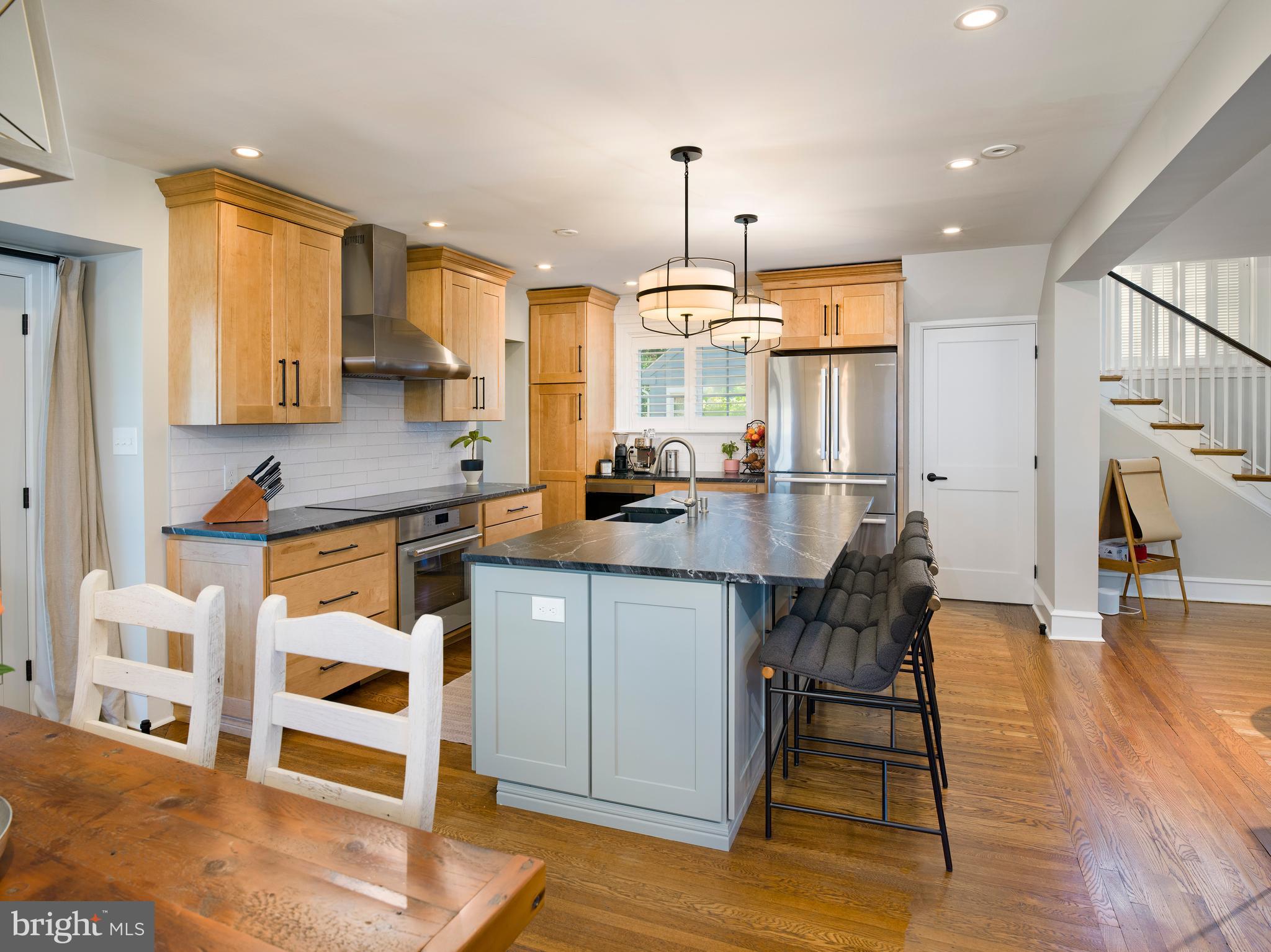 11 Shirley Road Narberth, PA 19072 - Photo 17 of 44 a kitchen with stainless steel appliances granite countertop a stove a sink dishwasher and a dining table with wooden floor
