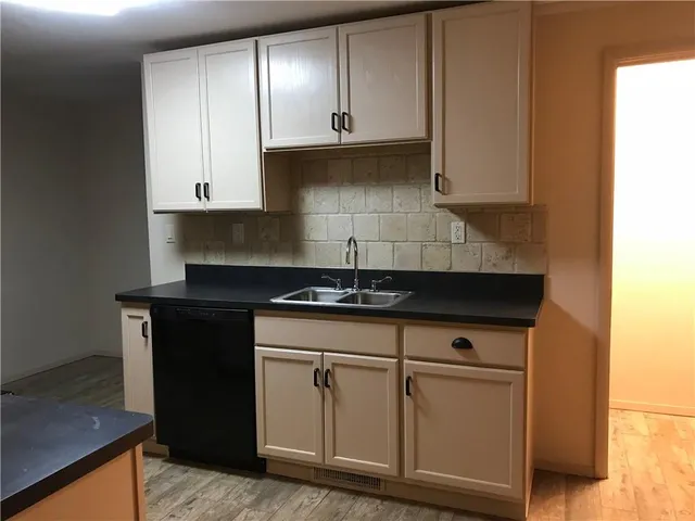 a kitchen with granite countertop a sink and cabinets