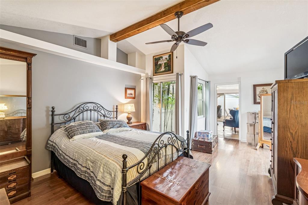 7740 Hawthorn Drive Port Richey, FL 34668 - Photo 11 of 27 a spacious bedroom with a bed a flat screen tv and a dresser