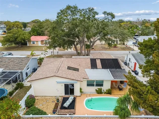 an aerial view of a house with a yard and large tree