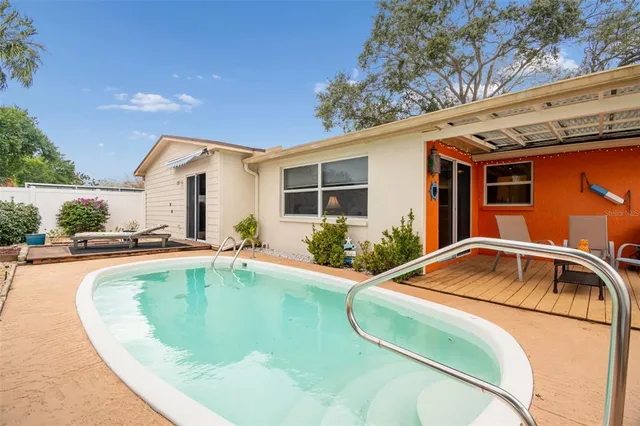 a house view with a swimming pool and seating space
