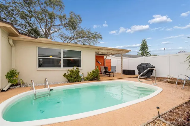 a view of a house with backyard and sitting area