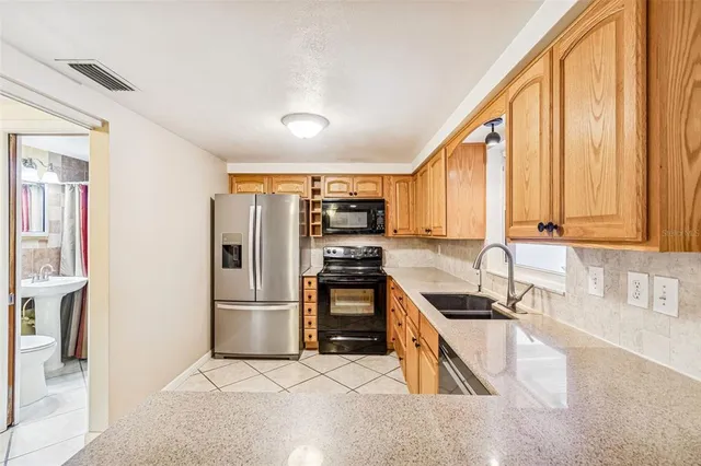 a kitchen with stainless steel appliances granite countertop a refrigerator and a sink