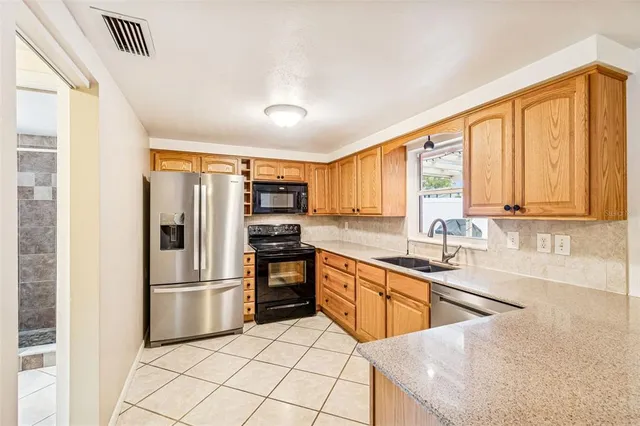a kitchen with stainless steel appliances granite countertop a refrigerator sink and cabinets