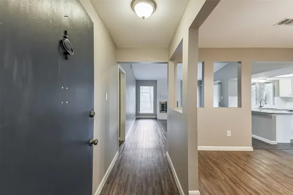 a view of a hallway with wooden floor and staircase