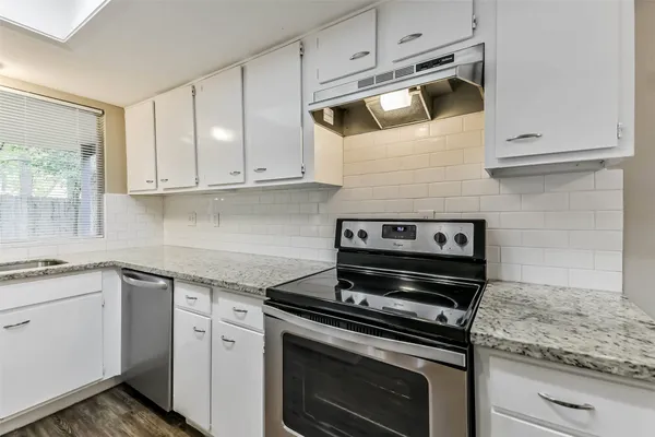 a kitchen with granite countertop a sink and a window