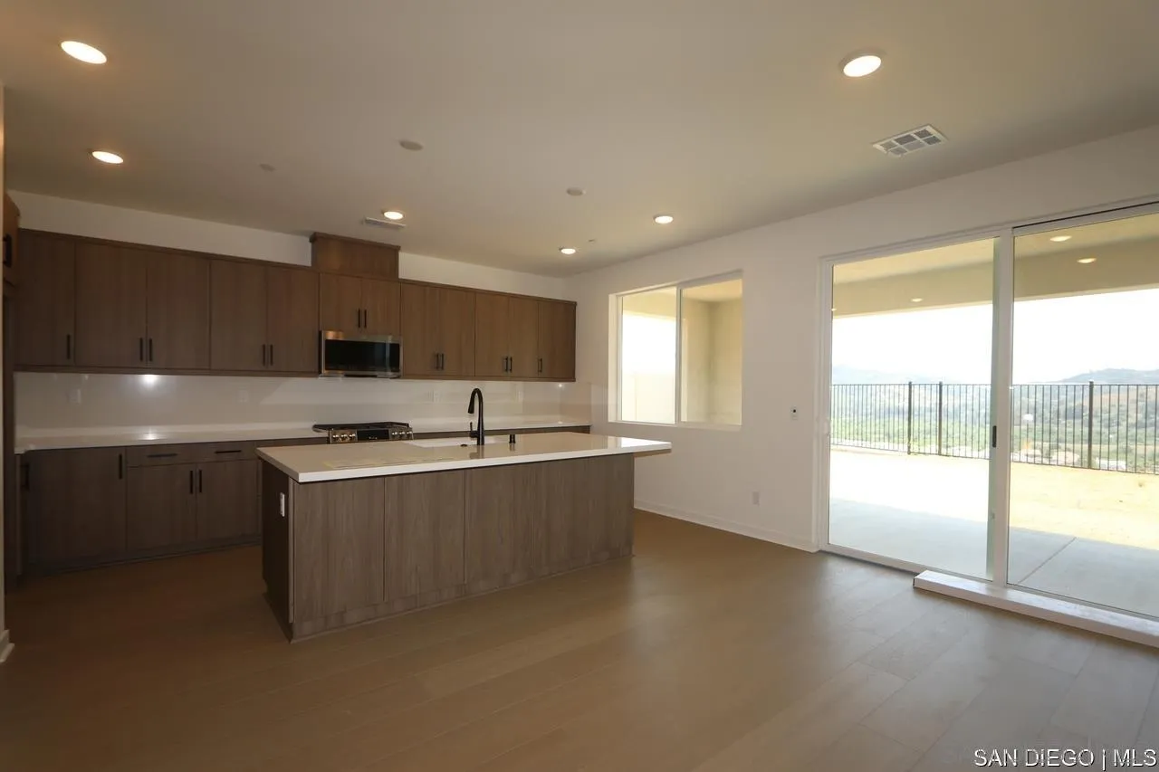 632 Meadowood Street Fallbrook, CA 92028 - Photo 5 of 21 a large kitchen with stainless steel appliances a large counter top