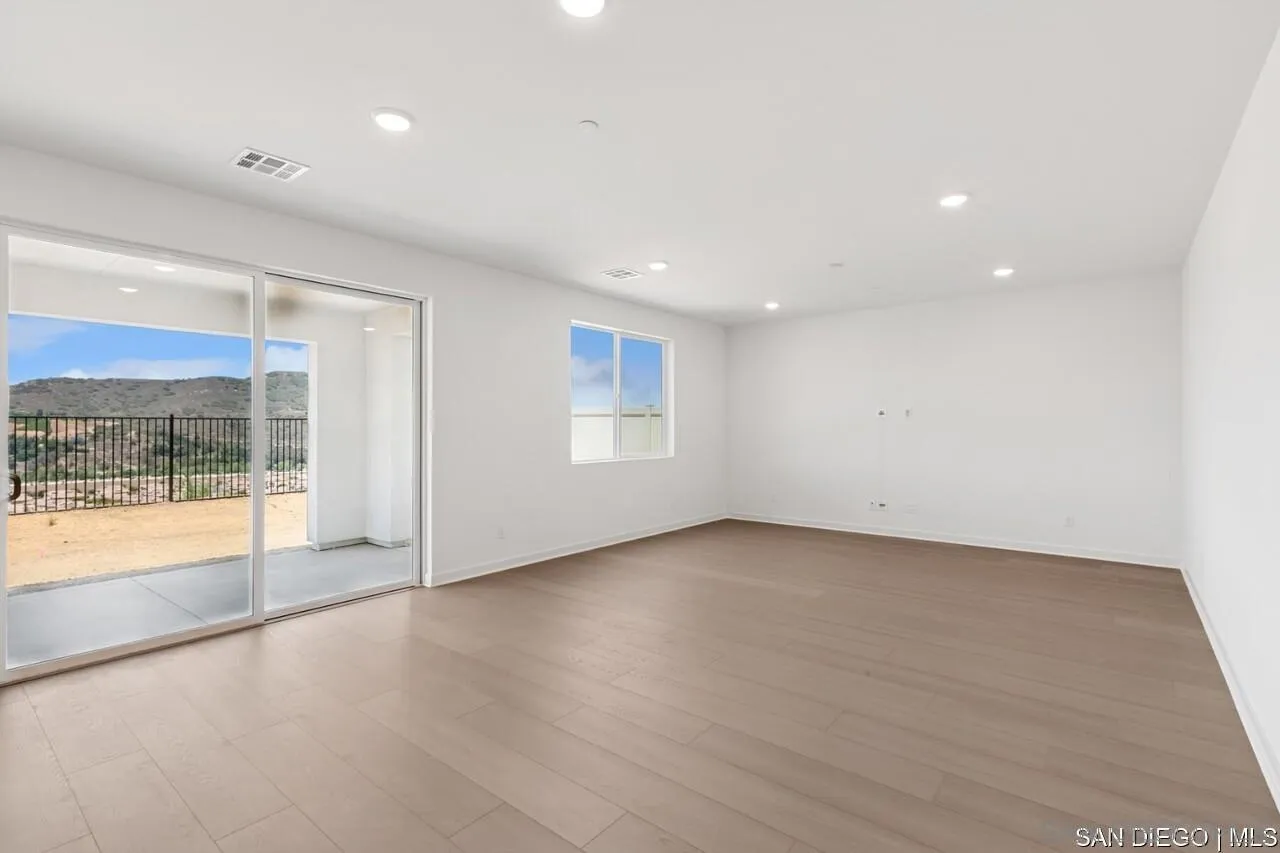 632 Meadowood Street Fallbrook, CA 92028 - Photo 6 of 21 an empty room with wooden floor and windows