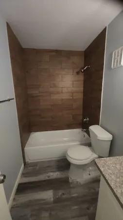 a bathroom with a granite countertop toilet and a shower