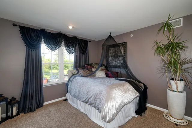 a bed room with a bed and a chair