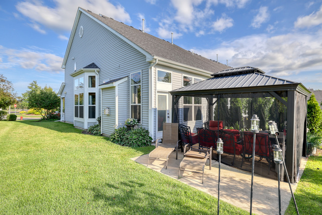 4579 Half Moon Drive, Unit D Yorkville, IL 60560 - Photo 25 of 44 a view of a house with backyard sitting area and garden