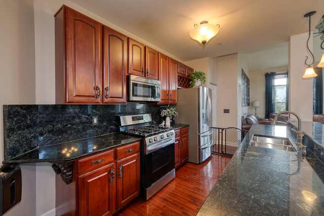4579 Half Moon Drive, Unit D Yorkville, IL 60560 - Photo 7 of 44 a kitchen with stainless steel appliances granite countertop a stove top oven a sink dishwasher a dining table and chairs with wooden floor