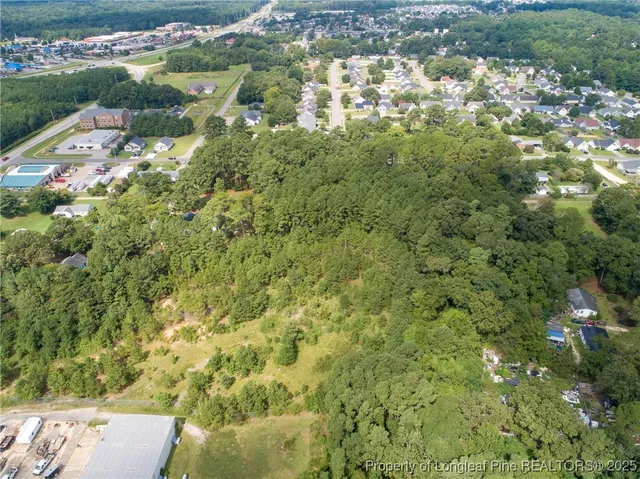 an aerial view of residential houses with outdoor space and trees