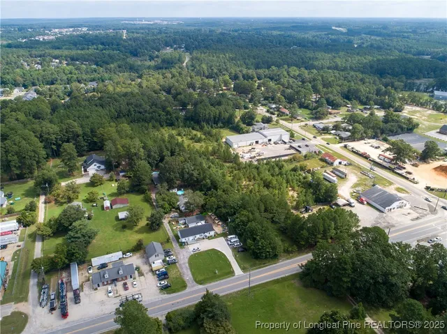 an aerial view of residential houses with outdoor space and trees