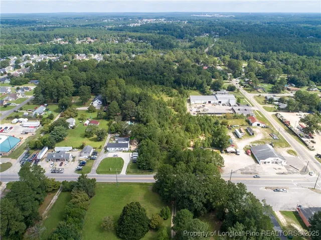 an aerial view of residential houses with outdoor space and trees