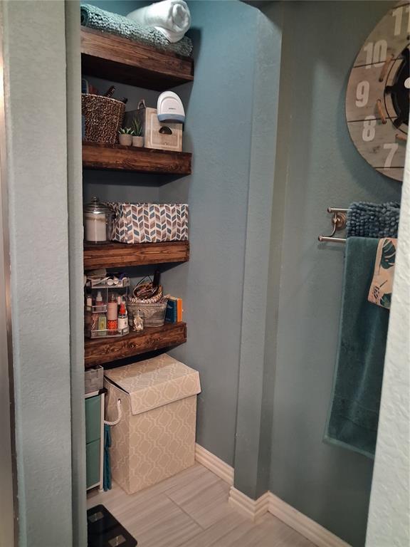 3600 Fox Ridge Road Lorena, TX 76655 - Photo 18 of 31 Built-in rustic wood shelving within an alcove, featuring a light blue wall finish and white baseboard trim