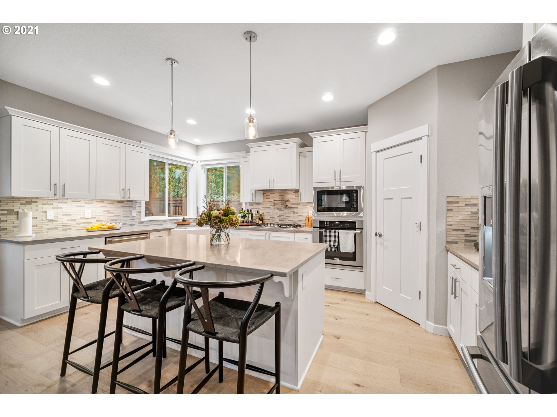 16215 Jada Way Oregon City, OR 97045 - Photo 12 of 32 a kitchen with stainless steel appliances kitchen island granite countertop a table chairs and a refrigerator