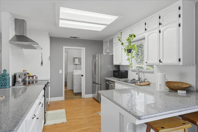 a kitchen with stainless steel appliances granite countertop a sink a stove counter space and cabinets
