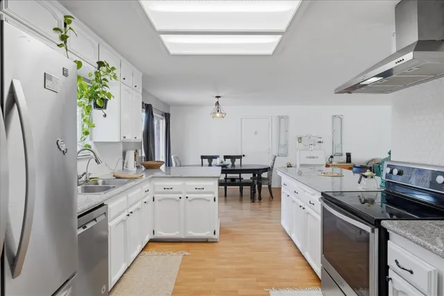 a kitchen with appliances a sink and cabinets