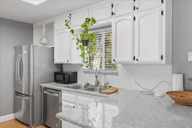 a kitchen with stainless steel appliances white cabinets and a refrigerator