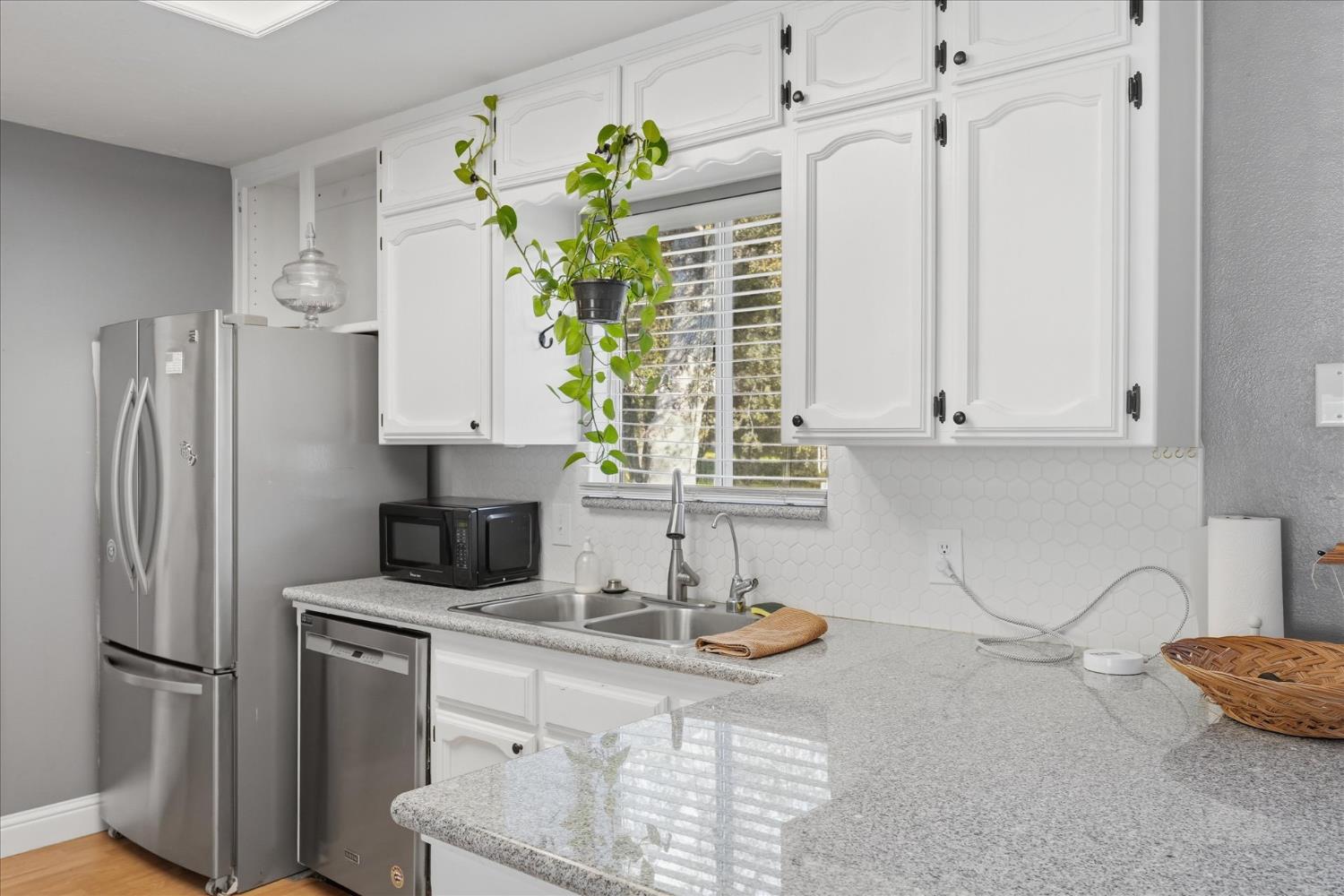 31083 Moccassin Court Coarsegold, CA 93614 - Photo 19 of 42 a kitchen with stainless steel appliances white cabinets and a refrigerator