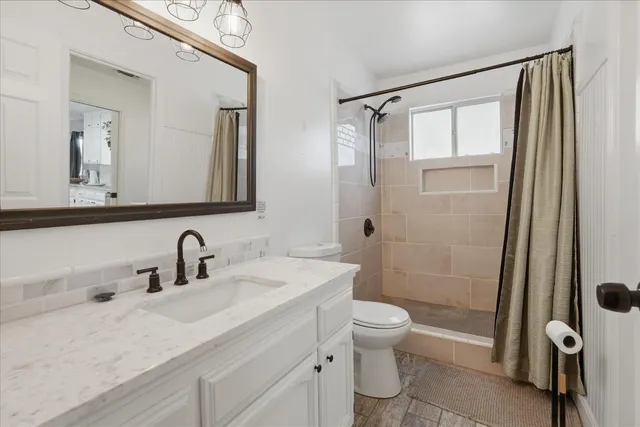 a bathroom with a sink a toilet and shower