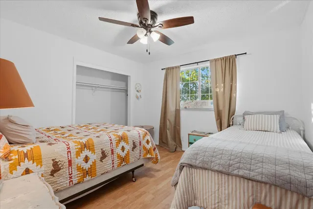 a bedroom with a large bed chandelier and a window