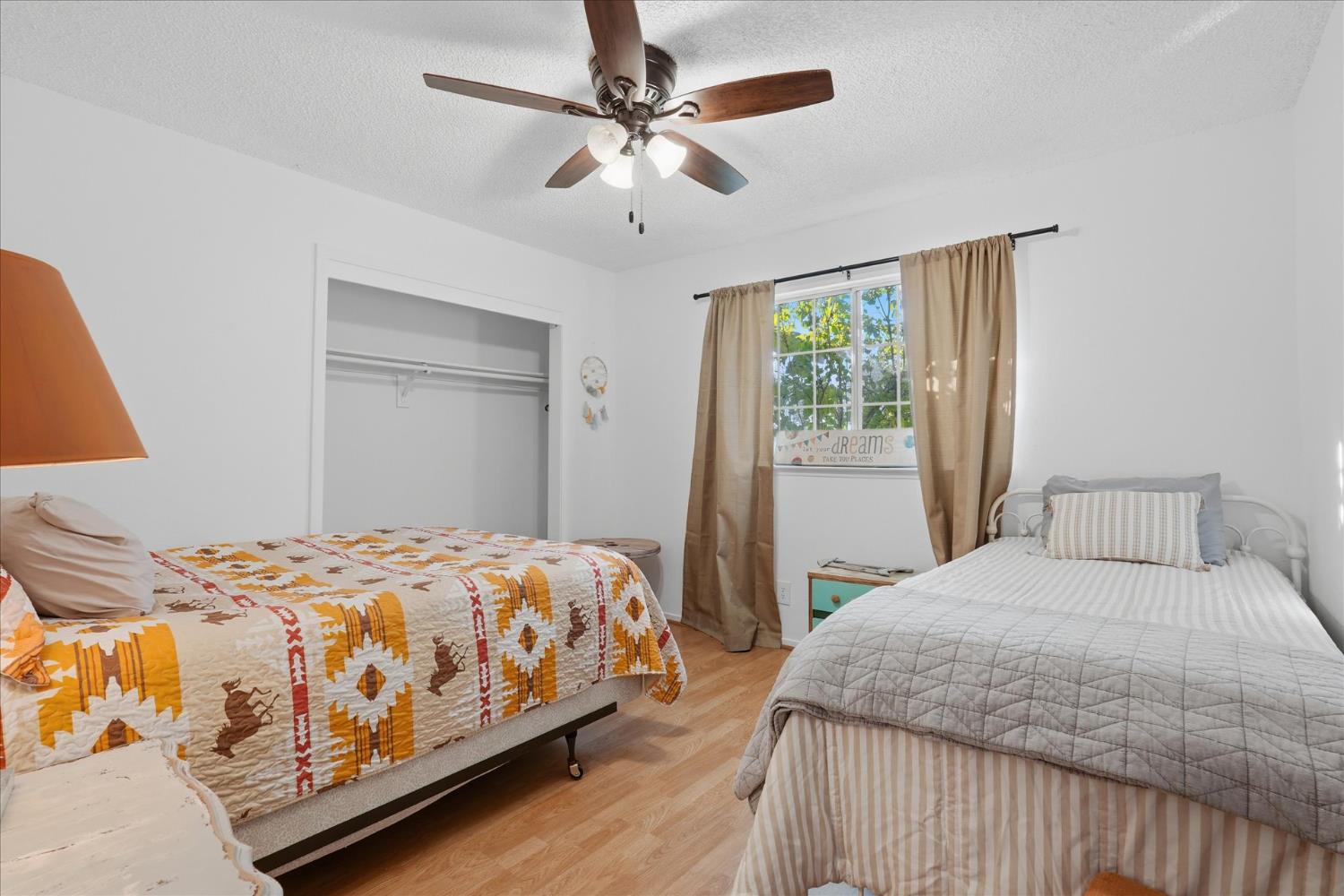 31083 Moccassin Court Coarsegold, CA 93614 - Photo 28 of 42 a bedroom with a large bed chandelier and a window