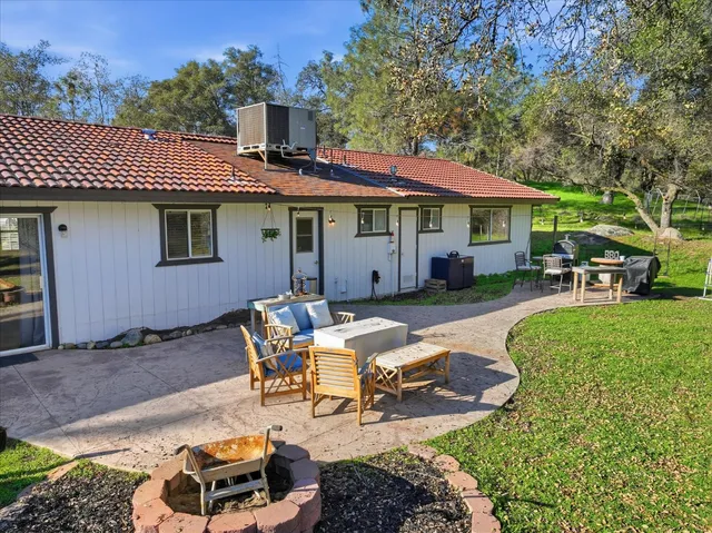 a view of a patio with table and chairs under an umbrella next to a yard