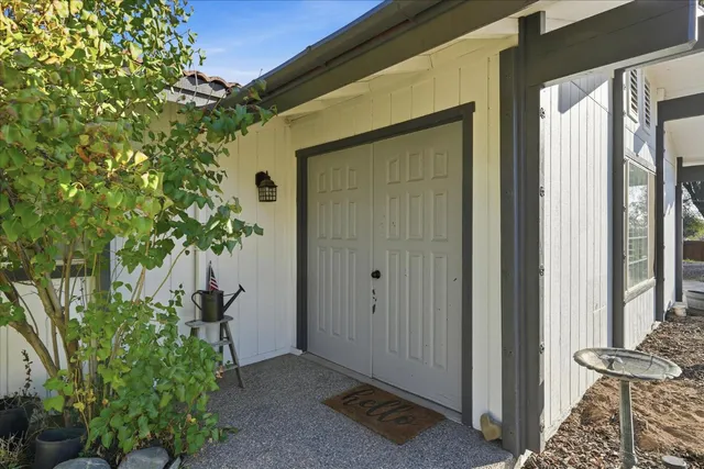 a backyard of a house with potted plants and wooden fence
