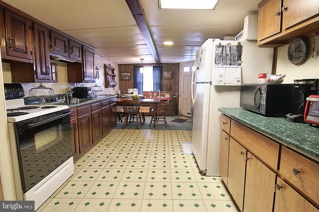 a kitchen with stainless steel appliances a sink a stove a refrigerator and cabinets