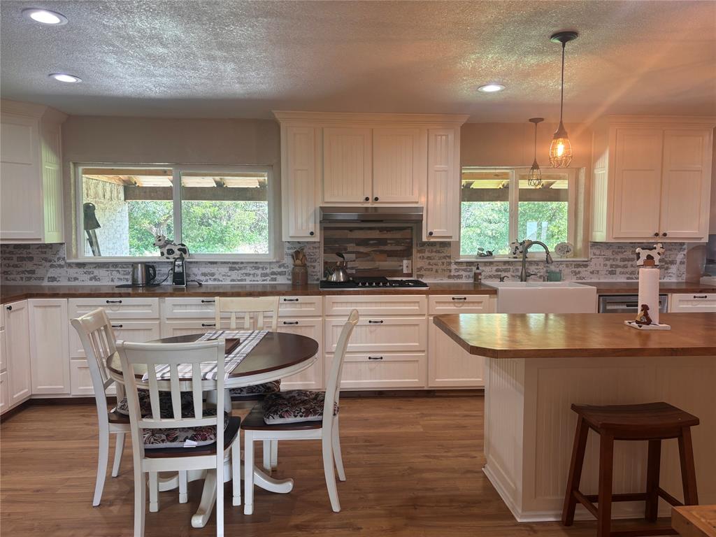 5355 Banks Road Fort Worth, TX 76140 - Photo 9 of 29 a kitchen with kitchen island granite countertop a table chairs sink and microwave