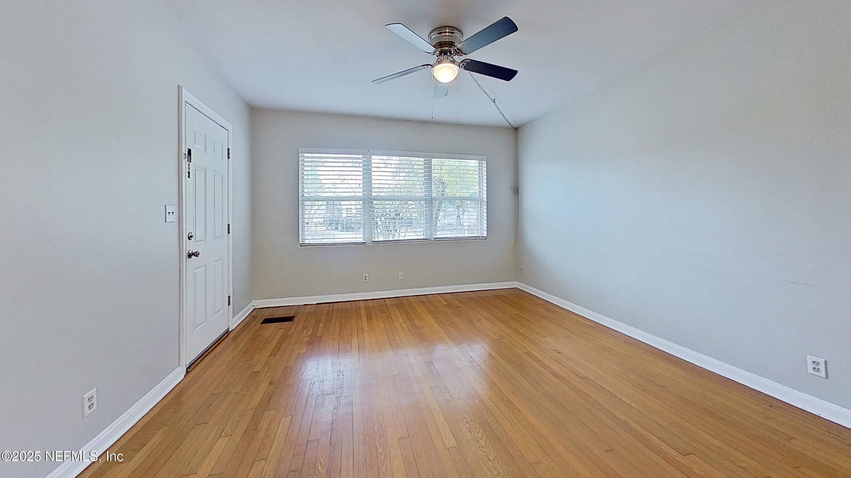 1543 Nicholson Road, Unit 1 Jacksonville, FL 32207 - Photo 7 of 16 wooden floor in an empty room with a window