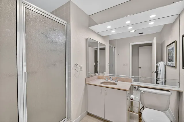 a bathroom with a sink mirror and a toilet