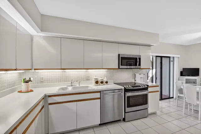 a kitchen with stainless steel appliances a sink stove and microwave