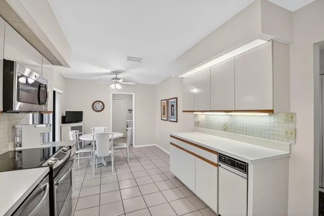 a open kitchen with stainless steel appliances kitchen island granite countertop a sink and chairs