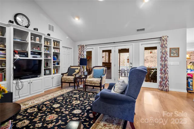 a living room with furniture a flat screen tv and a floor to ceiling window