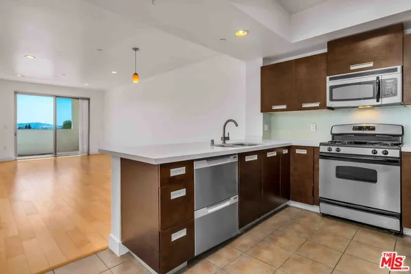 a kitchen with stainless steel appliances a stove a microwave and a sink