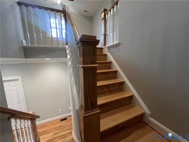 an empty room with wooden floor and entrance