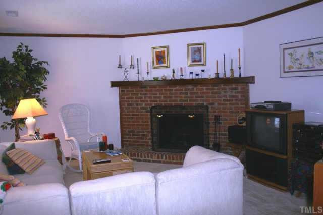 5670 Hamstead Crossing Raleigh, NC 27612 - Photo 2 of 10 Natural wood brick fireplace in large living room with great light Other