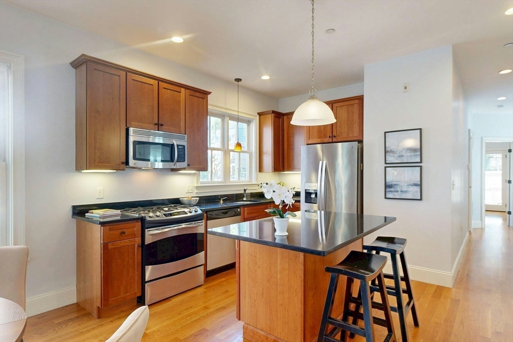 16 A Meehan Street, Unit 1 Boston, MA 02130 - Photo 5 of 16 a kitchen with stainless steel appliances granite countertop a stove top oven a sink and a refrigerator