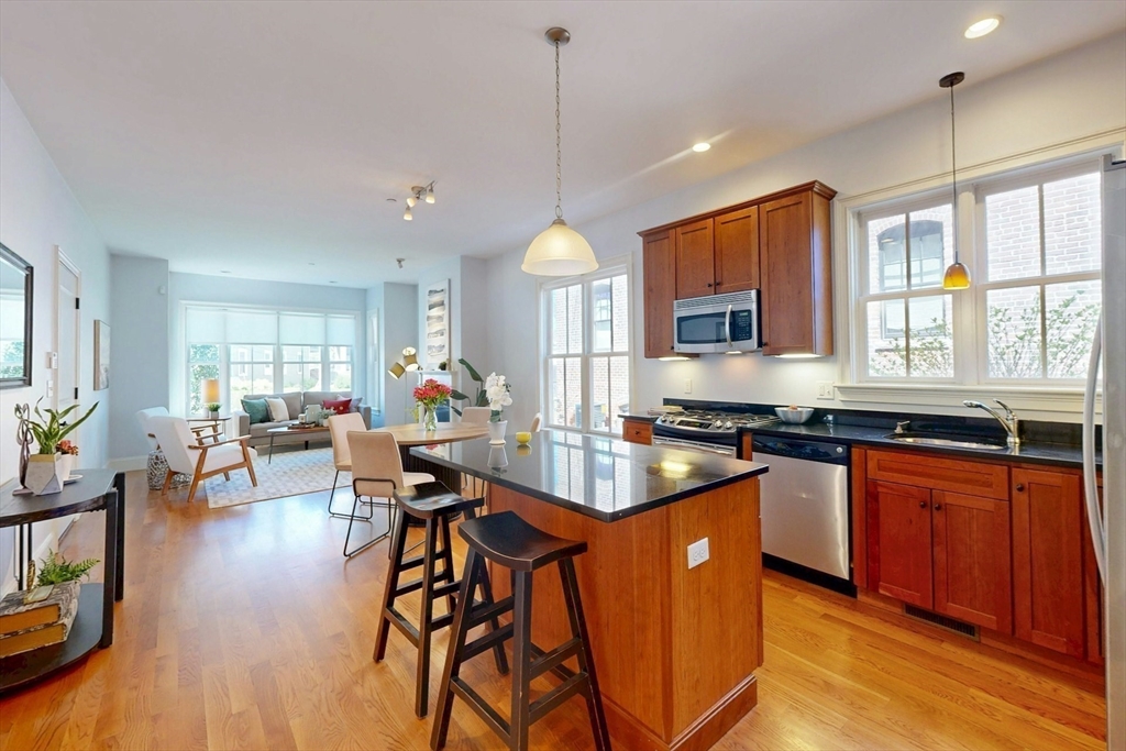 16 A Meehan Street, Unit 1 Boston, MA 02130 - Photo 6 of 16 a kitchen with stainless steel appliances granite countertop wooden floors stove top oven and cabinets