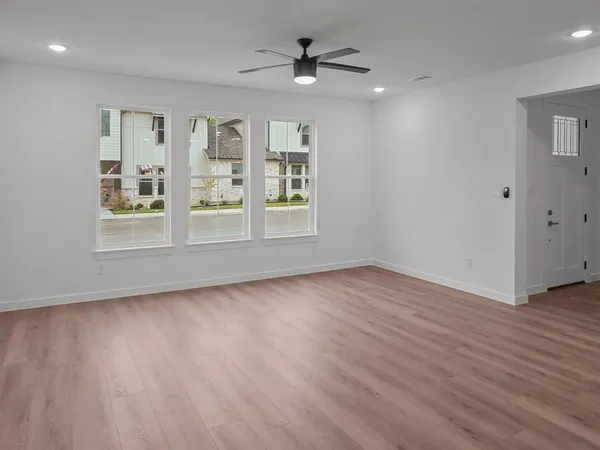 an empty room with wooden floor and windows