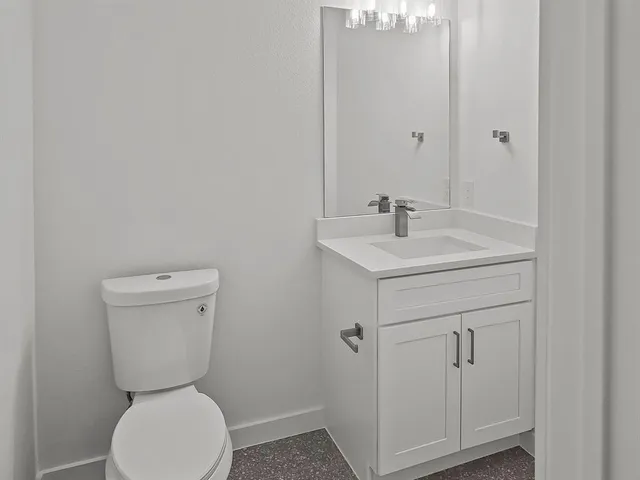 a bathroom with a toilet sink and mirror